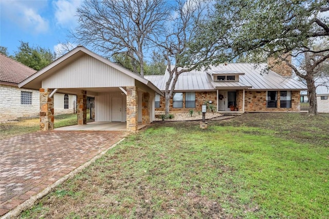 207 Lasso St, Horseshoe Bay, TX 78657 - view of front of home featuring stone siding, a front yard, metal roof, decorative driveway, and an attached carport