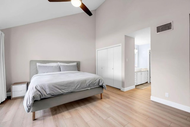 207 Lasso St, Horseshoe Bay, TX 78657 - bedroom with light wood-style flooring, a closet, ensuite bath, a ceiling fan, and a towering ceiling