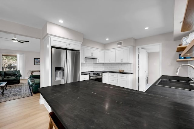 207 Lasso St, Horseshoe Bay, TX 78657 - kitchen with appliances with stainless steel finishes, dark countertops, white cabinets, a ceiling fan, and recessed lighting