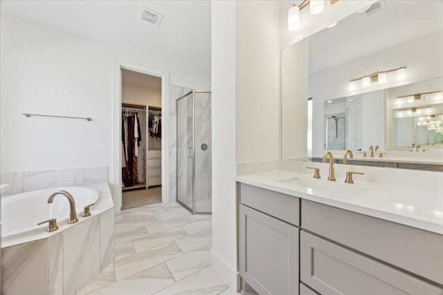 bathroom with a shower stall, a spacious closet, visible vents, vanity, and a bath
