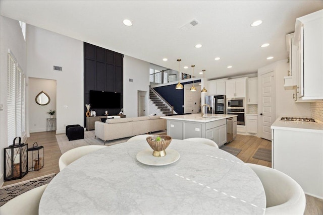 dining room with recessed lighting, stairway, visible vents, and light wood-type flooring