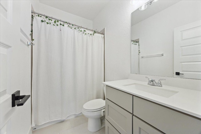 full bathroom featuring toilet, vanity, and tile patterned floors