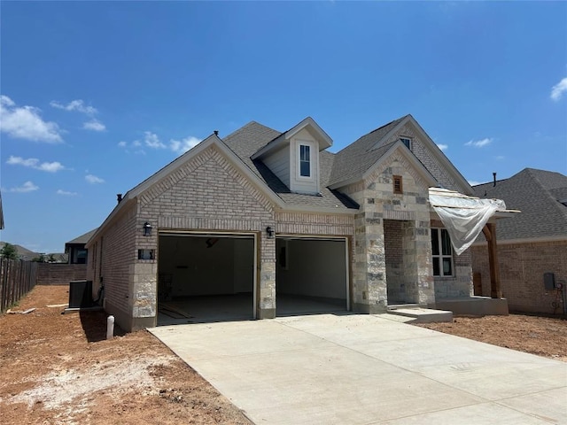 8213 Grenadier Dr, Austin, TX 78738 - view of front of home with driveway, stone siding, an attached garage, and brick siding
