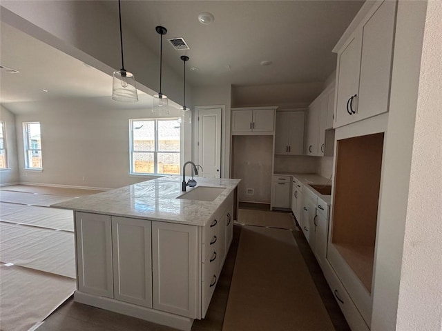 8213 Grenadier Dr, Austin, TX 78738 - kitchen featuring a sink, white cabinets, an island with sink, and light stone countertops