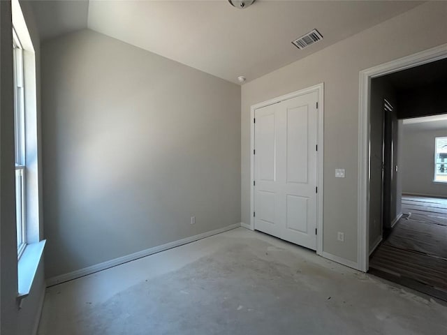 8213 Grenadier Dr, Austin, TX 78738 - unfurnished bedroom featuring unfinished concrete flooring, baseboards, and lofted ceiling