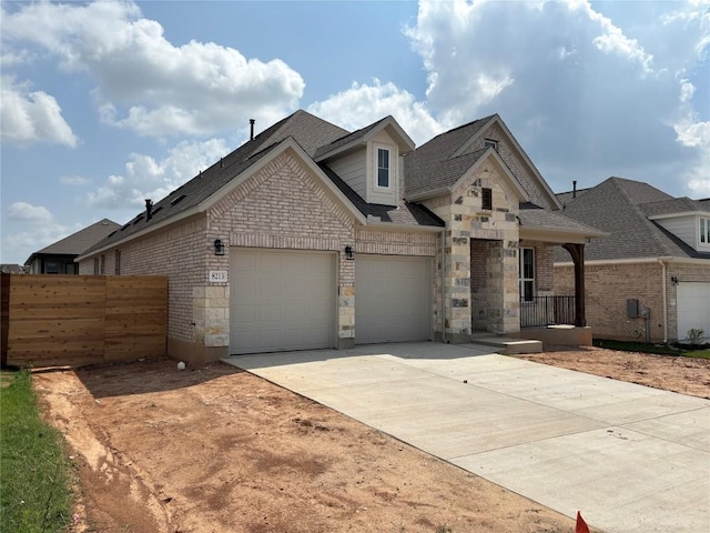 8213 Grenadier Dr, Austin, TX 78738 - view of front of house featuring a garage, concrete driveway, roof with shingles, brick siding, and stone siding