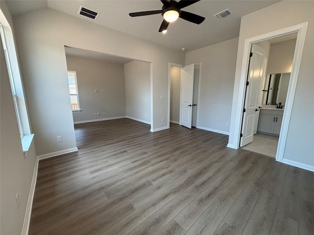 8213 Grenadier Dr, Austin, TX 78738 - unfurnished bedroom featuring wood finished floors, connected bathroom, and a ceiling fan
