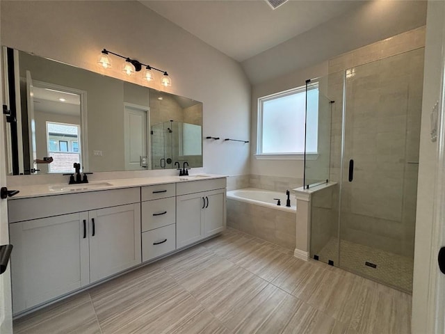 8213 Grenadier Dr, Austin, TX 78738 - bathroom featuring a bath, a stall shower, double vanity, vaulted ceiling, and tile patterned floors