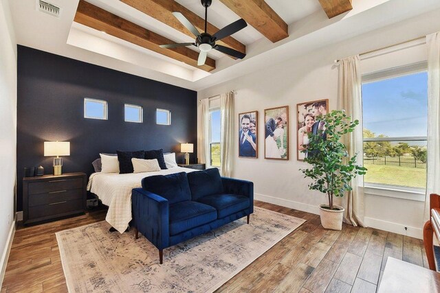 308 Somerset Hills Dr, Georgetown, TX 78633 - bedroom featuring wood finished floors, multiple windows, beamed ceiling, and a raised ceiling