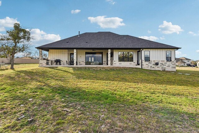 308 Somerset Hills Dr, Georgetown, TX 78633 - rear view of property with board and batten siding, a patio area, and a lawn