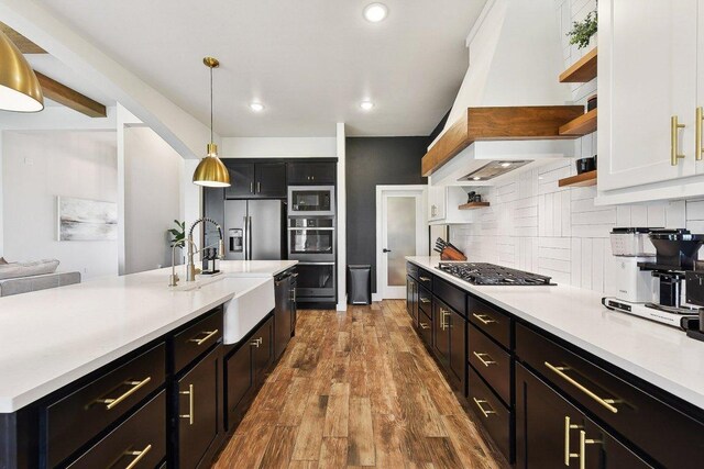 308 Somerset Hills Dr, Georgetown, TX 78633 - kitchen with open shelves, appliances with stainless steel finishes, light countertops, decorative backsplash, and wood finished floors