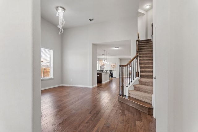 13601 Larrys Ln, Manchaca, TX 78652 - entrance foyer with dark wood-type flooring, stairs, visible vents, and a notable chandelier