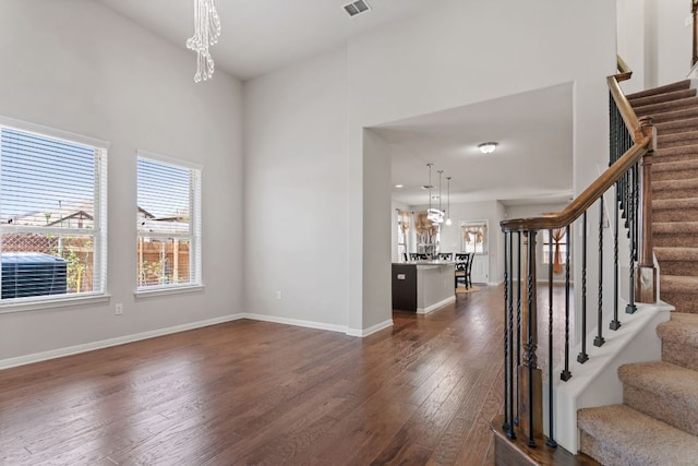 13601 Larrys Ln, Manchaca, TX 78652 - interior space with stairway, a chandelier, baseboards, visible vents, and dark wood-type flooring