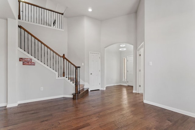13601 Larrys Ln, Manchaca, TX 78652 - entrance foyer featuring stairs, baseboards, a towering ceiling, arched walkways, and wood finished floors