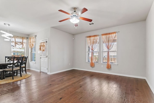 13601 Larrys Ln, Manchaca, TX 78652 - unfurnished living room with ceiling fan with notable chandelier, visible vents, baseboards, and wood-type flooring