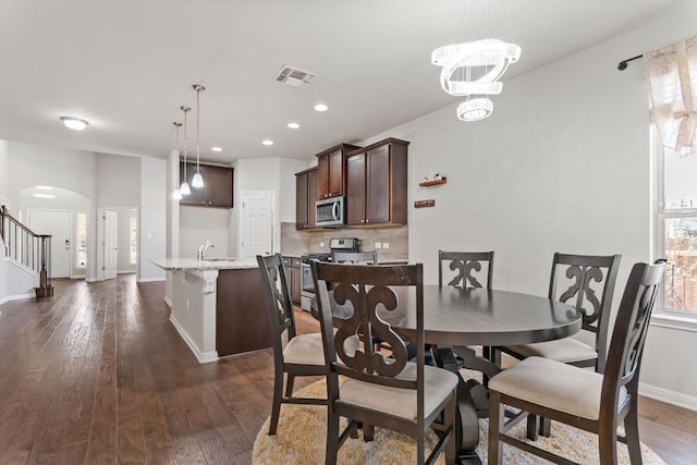 13601 Larrys Ln, Manchaca, TX 78652 - dining area with arched walkways, dark wood-style floors, baseboards, and visible vents