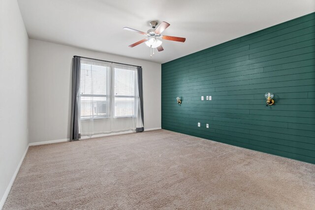 13601 Larrys Ln, Manchaca, TX 78652 - spare room featuring baseboards, carpet floors, an accent wall, and a ceiling fan