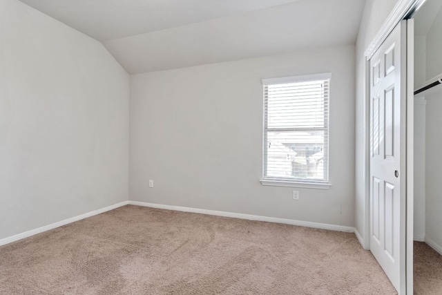 13601 Larrys Ln, Manchaca, TX 78652 - unfurnished bedroom with vaulted ceiling, baseboards, a closet, and light colored carpet