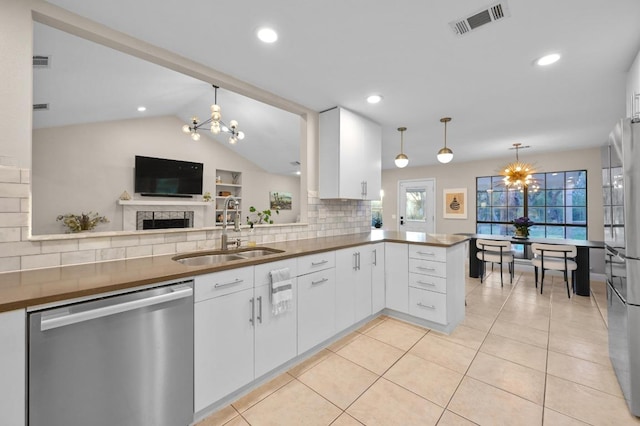 11100 Centennial Trl, Austin, TX 78726 - kitchen featuring stainless steel appliances, a chandelier, decorative backsplash, a peninsula, and white cabinetry
