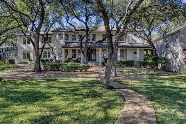 2610 Allston Ln, Austin, TX 78746 - view of front of property with a front lawn, stucco siding, and covered porch