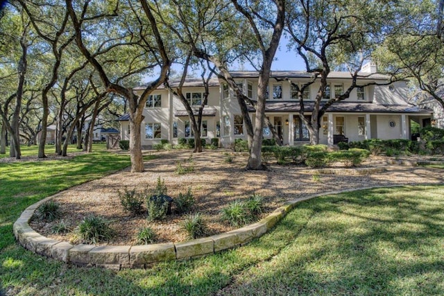 2610 Allston Ln, Austin, TX 78746 - view of front facade with a front yard, a chimney, and stucco siding
