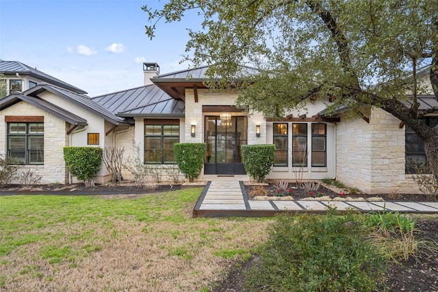 4229 Verano Dr, Austin, TX 78735 - view of front facade with a standing seam roof, a front yard, stone siding, a chimney, and a metal roof