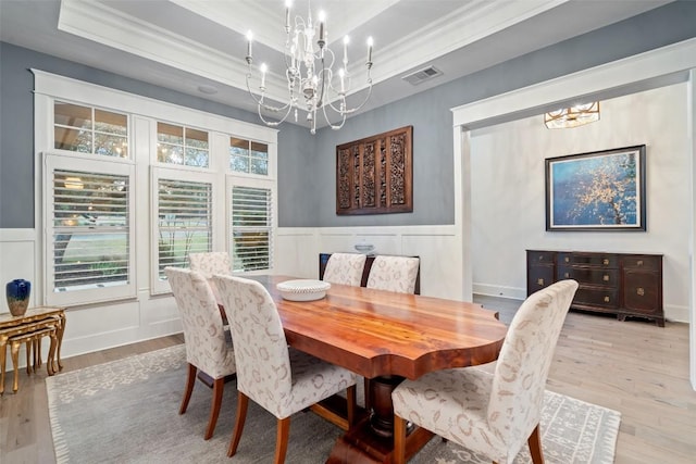 4229 Verano Dr, Austin, TX 78735 - dining area with a chandelier, crown molding, a tray ceiling, wood finished floors, and wainscoting