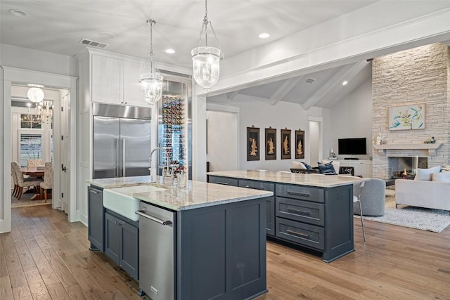 4229 Verano Dr, Austin, TX 78735 - kitchen featuring built in fridge, a kitchen island with sink, a chandelier, light wood finished floors, and recessed lighting