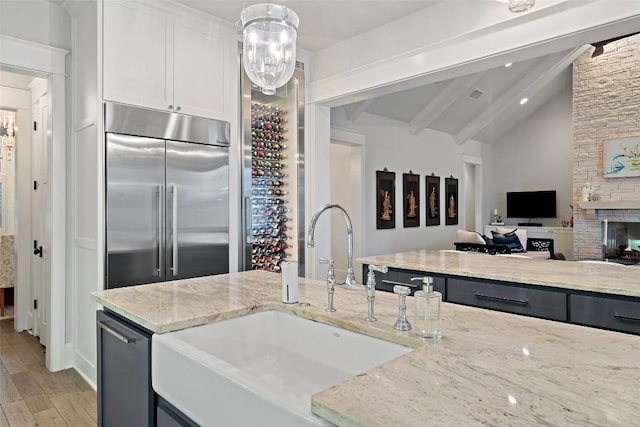 4229 Verano Dr, Austin, TX 78735 - kitchen featuring built in fridge, light wood-type flooring, light stone counters, white cabinetry, and open floor plan