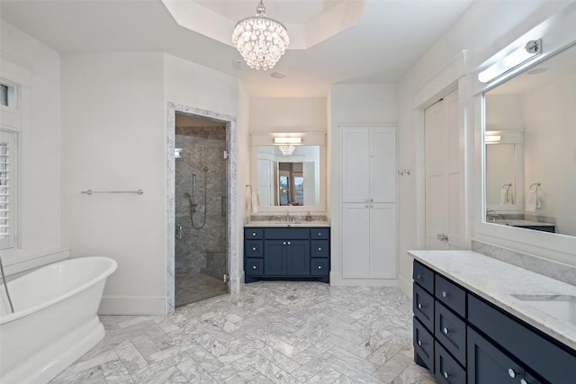 4229 Verano Dr, Austin, TX 78735 - bathroom featuring a stall shower, a freestanding tub, two vanities, a chandelier, and marble finish floors