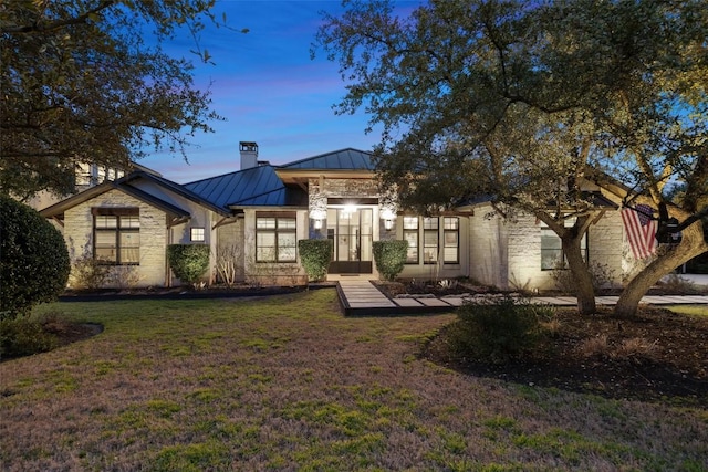 4229 Verano Dr, Austin, TX 78735 - view of front of property with a standing seam roof, stone siding, a yard, a metal roof, and a chimney