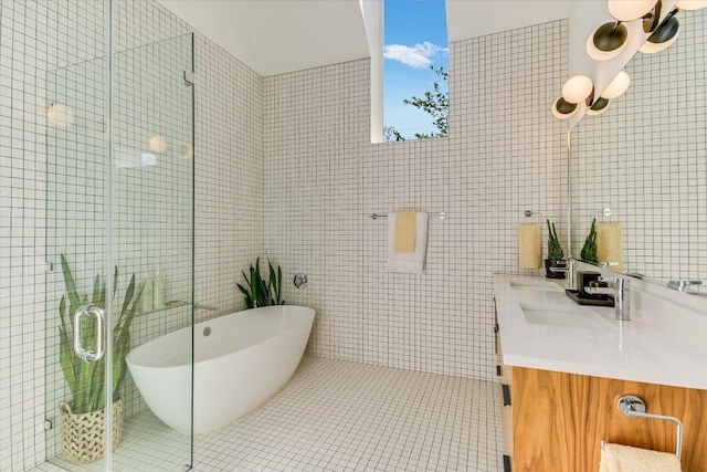 2010 Goodrich Ave Unit 8A, Austin, TX 78704 - full bathroom with double vanity, a freestanding tub, a shower stall, tile walls, and tile patterned floors