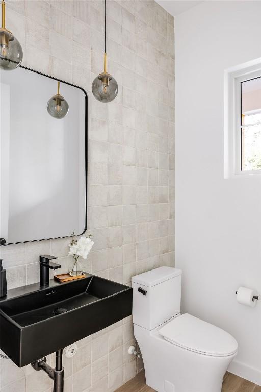 3607 Garden Villa Ln, Austin, TX 78704 - half bath with toilet, a sink, and tasteful backsplash