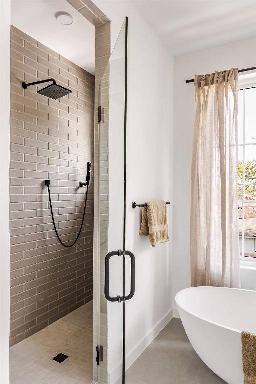 3607 Garden Villa Ln, Austin, TX 78704 - bathroom featuring a stall shower, a soaking tub, and baseboards