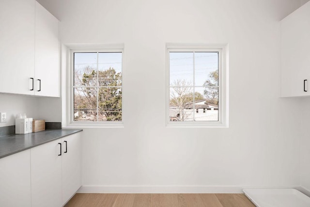 3607 Garden Villa Ln, Austin, TX 78704 - kitchen with white cabinetry, light wood finished floors, and dark countertops