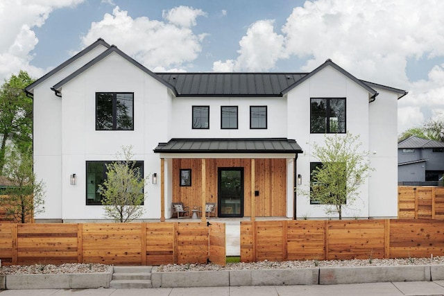 3607 Garden Villa Ln, Austin, TX 78704 - modern farmhouse style home with covered porch, a standing seam roof, a fenced front yard, a metal roof, and stucco siding