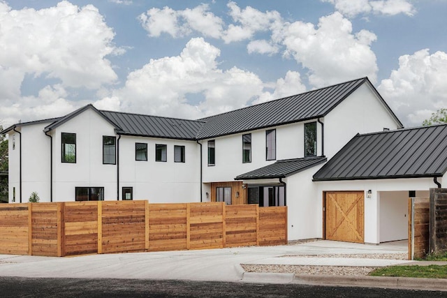 3607 Garden Villa Ln, Austin, TX 78704 - modern inspired farmhouse featuring a standing seam roof, stucco siding, a fenced front yard, a metal roof, and a garage