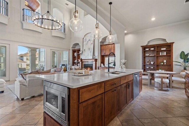 11901 Preserve Vista Ter, Austin, TX 78738 - kitchen with appliances with stainless steel finishes, open floor plan, a sink, crown molding, and a large fireplace