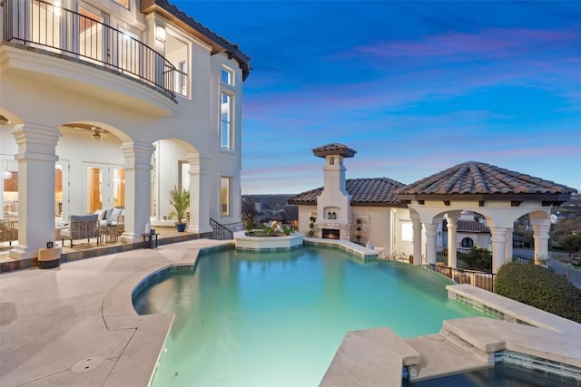11901 Preserve Vista Ter, Austin, TX 78738 - pool at dusk featuring a lit fireplace, a patio area, a pool with connected hot tub, and a gazebo