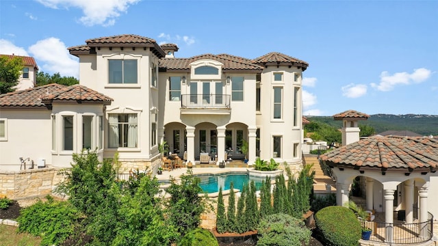 11901 Preserve Vista Ter, Austin, TX 78738 - back of property featuring a balcony, a tile roof, stucco siding, a patio, and an outdoor pool