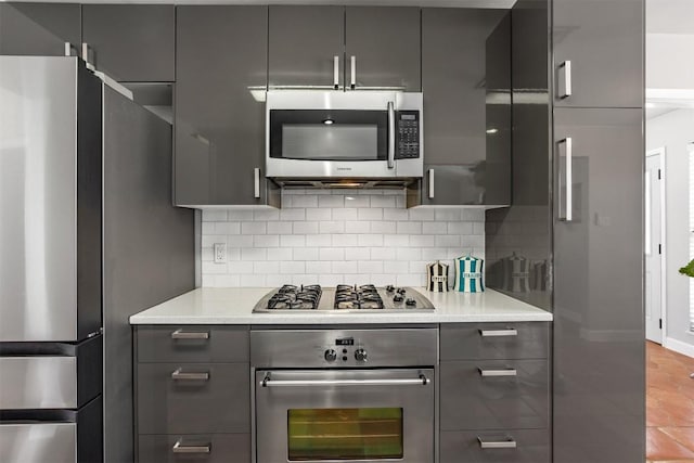 1908 Running Brook Dr, Austin, TX 78723 - kitchen with appliances with stainless steel finishes, gray cabinetry, decorative backsplash, modern cabinets, and light countertops