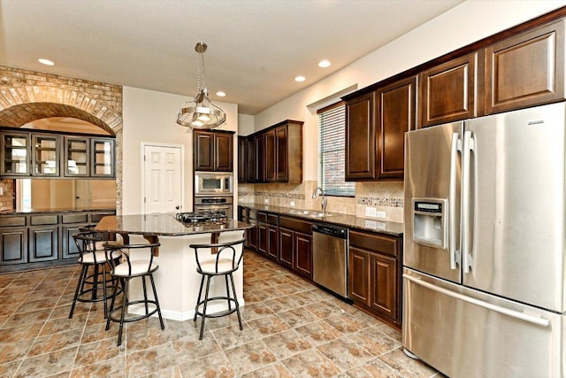 412 Madisons Way, Cedar Park, TX 78613 - kitchen with stainless steel appliances, decorative backsplash, a kitchen bar, dark stone countertops, and dark brown cabinetry
