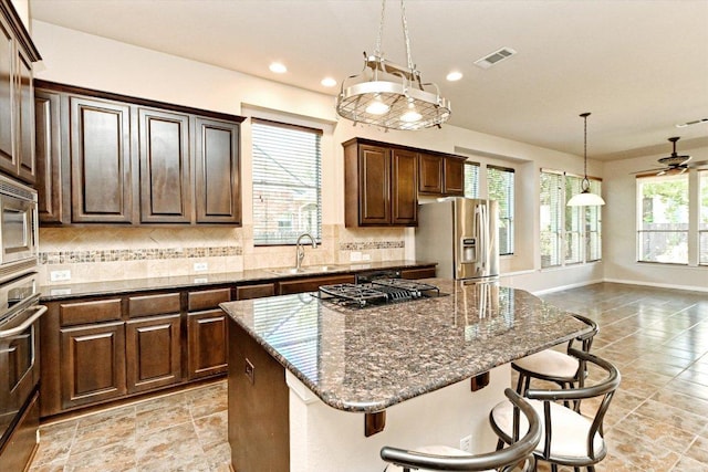 412 Madisons Way, Cedar Park, TX 78613 - kitchen featuring appliances with stainless steel finishes, decorative backsplash, a center island, a breakfast bar, and recessed lighting