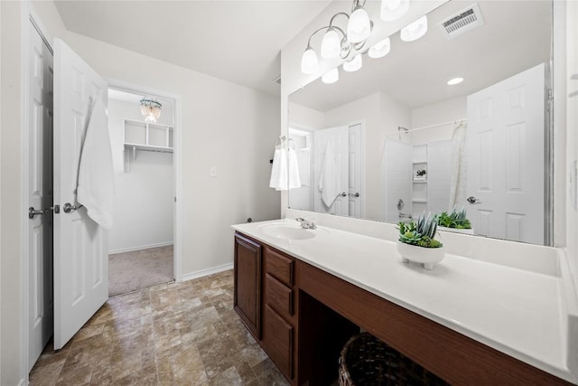 full bath with curtained shower, vanity, stone finish floor, baseboards, and visible vents