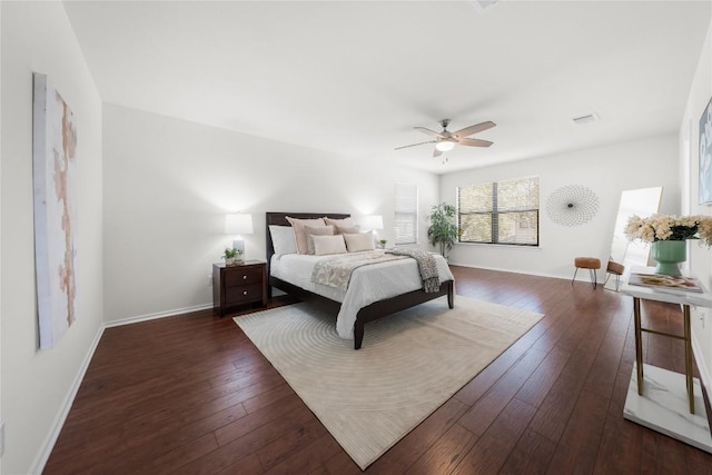 bedroom with hardwood / wood-style floors, baseboards, visible vents, and a ceiling fan