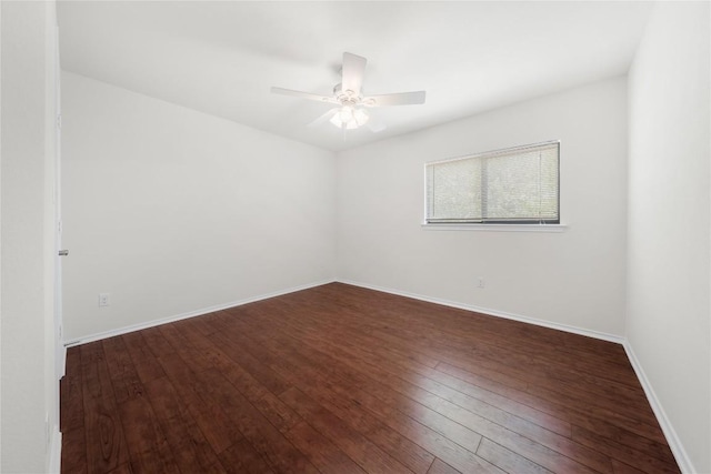 unfurnished room with baseboards, a ceiling fan, and dark wood-style flooring