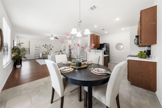 dining space featuring visible vents, baseboards, recessed lighting, light wood-style floors, and ceiling fan with notable chandelier