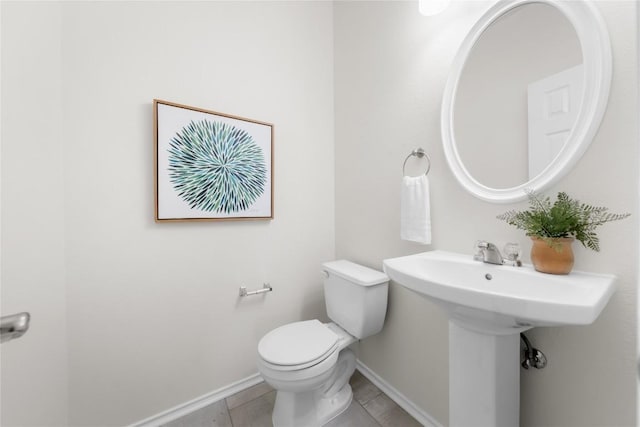 bathroom featuring baseboards, toilet, and tile patterned flooring