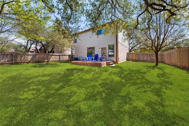 back of property featuring a fenced backyard and a yard