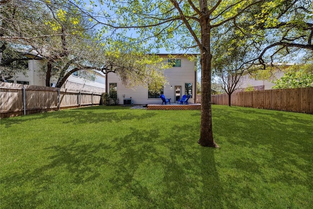 view of yard with a fenced backyard and central air condition unit